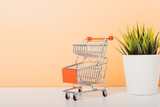 Mock up shoppong online cart on desk table office soft yellow wall