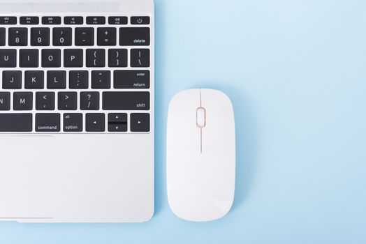 Top view laptop computer notebook and wireless mouse isolated on blue background