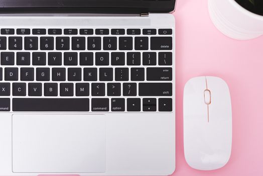 Top view laptop computer notebook and wireless mouse isolated on pink background