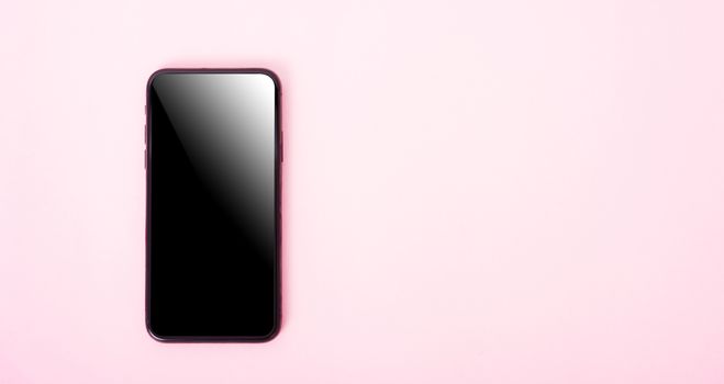 Top view of modern technology smart phone mobile on pink background with copy space