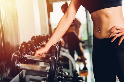 Hand of woman weights dumbbell equipment at fitness gym