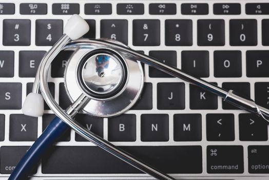 Health stethoscope on keyboard of laptop computer, medical concept