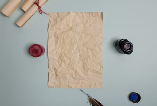 Raven feather, inkwell and old yellowed paper on red background. Copy space. Old letter.