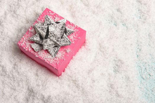 christmas presents nicely decorated with bows and feathers in snow. view from above