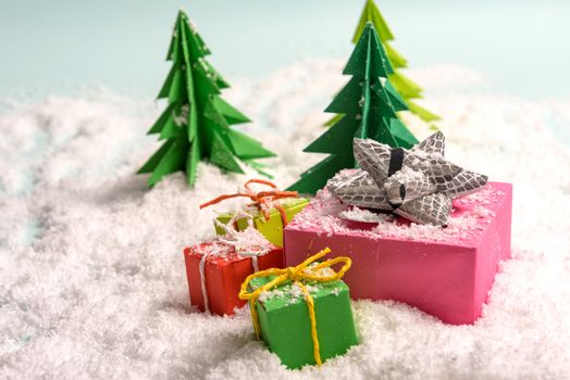 christmas presents nicely decorated with bows and feathers in snow. view from above