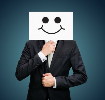 Businessman standing white paper happy smile face holding front of head on dark background