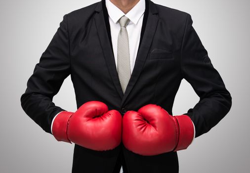 Businessman standing posture in boxing gloves isolated on over gray background