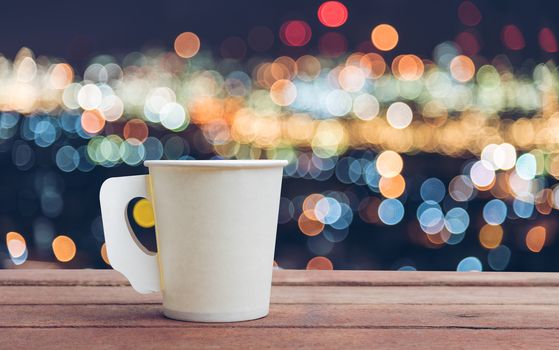 Paper cup coffee on the wooden table with bokeh background