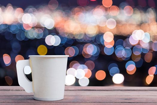 Paper cup coffee on the wooden table with bokeh background