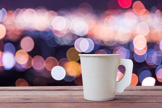 Paper cup coffee on the wooden table with bokeh background