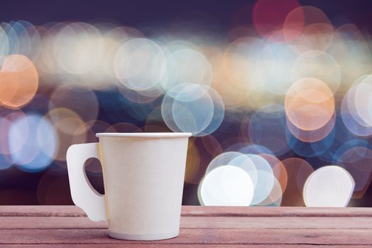 Paper cup coffee on the wooden table with bokeh background