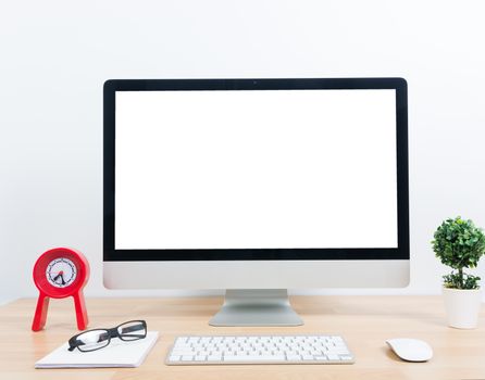 Office monitor computer, mouse on wooden table and white wall background