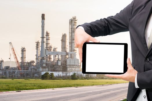 Engineering working hold tablet in front of oil refinery power station