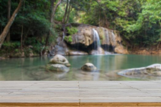 Wooden plank and background with Blur Waterfall Erawan Park