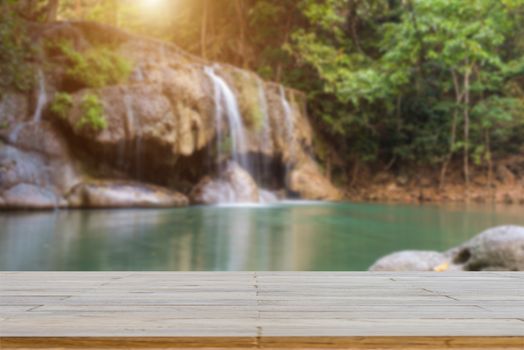Wooden plank and background with Blur Waterfall Erawan Park