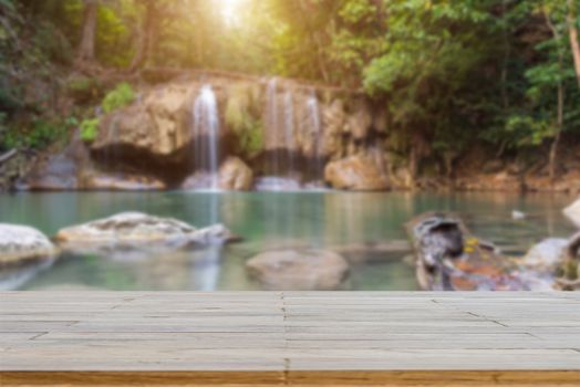 Wooden plank and background with Blur Waterfall Erawan Park