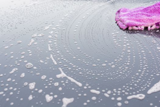 Closeup cleaning his car using gloves car wash gray color