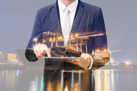 Double exposure of businessman hand hold tablet, cargo port ship at sea port concept