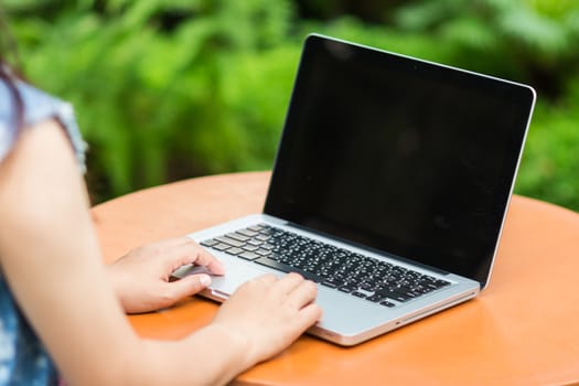 Woman hands typing on laptop outdoors in cafe
