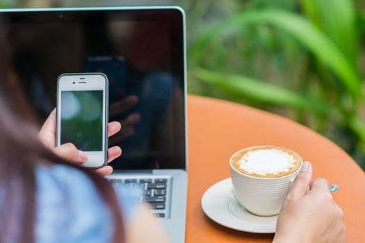 Woman hands typing on laptop outdoors in cafe