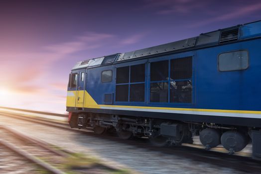 Fast freight blue train at sunset with motion blur