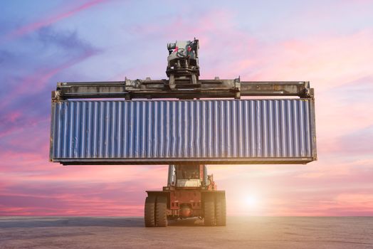 Forklift handling container box loading in the port at Thailand at sunset