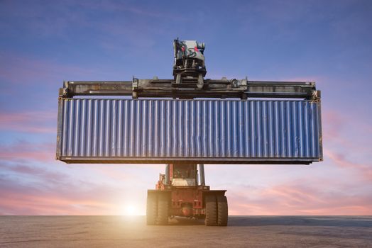 Forklift handling container box loading in the port at Thailand at sunset