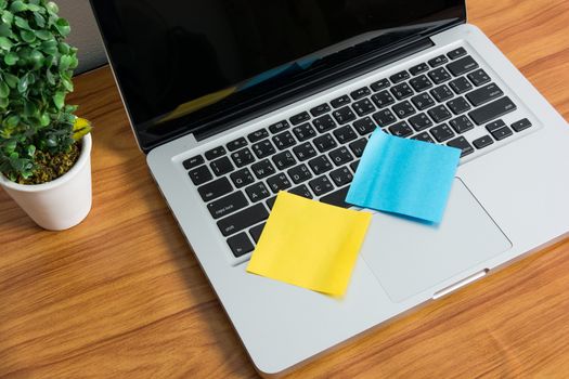 Laptop and stick note on wooden table