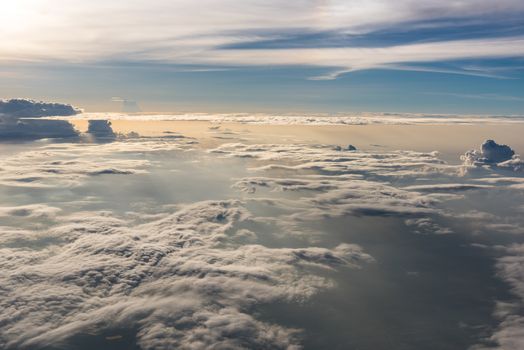 Many cloud in Flying above sunrise, view from outside airplane