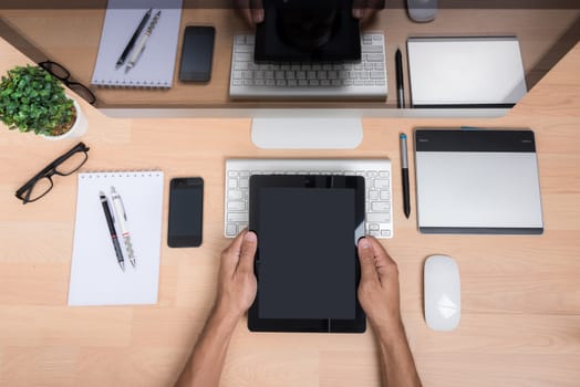 Top view office hand working with Tablet, mobile phone, keyboard mouse, computer PC, on wooden desk