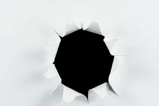 Breakthrough torn big black hole in white paper isolated background