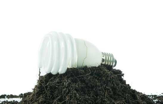 Pile of soil with light bulb green energy concept isolated on over white background