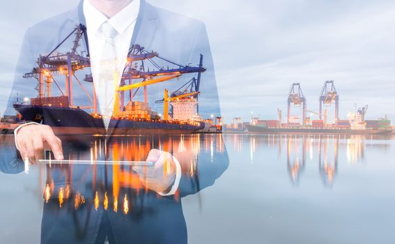 Double exposure of businessman hand hold tablet, cargo port ship at sea port concept