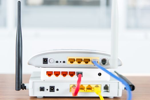 Wireless modem router network hub with cable connect on wooden table in the room