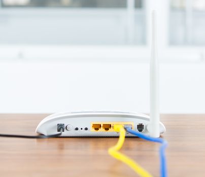 Wireless modem router network hub with cable connect on wooden table in the room