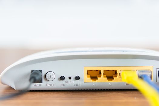 Wireless modem router network hub with cable connect on wooden table in the room