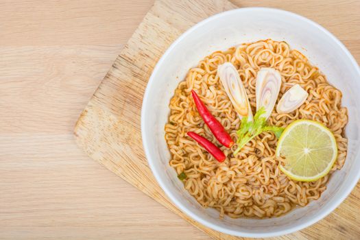 Hot and spicy instant noodle on wooden background