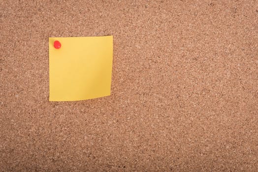 Yellow blank note papers with pin on wooden board background