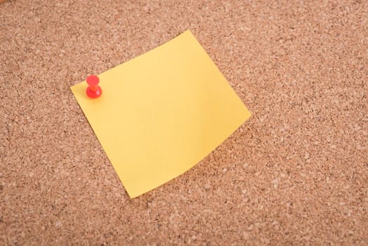 Yellow blank note papers with pin on wooden board background