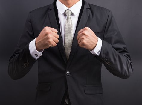 Young businessman with no boxing gloves isolated on black background