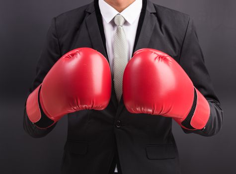 Young businessman with boxing gloves isolated on black background