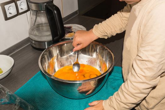 Little boy helps in the kitchen while baking cake.