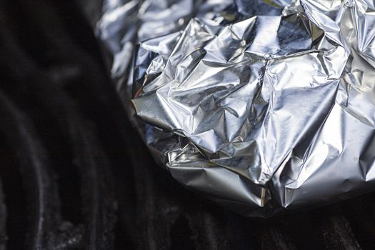 macro shot of tin foil wrapped food on the grill