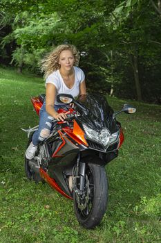 Gorgeous blond woman riding a sport motocycle