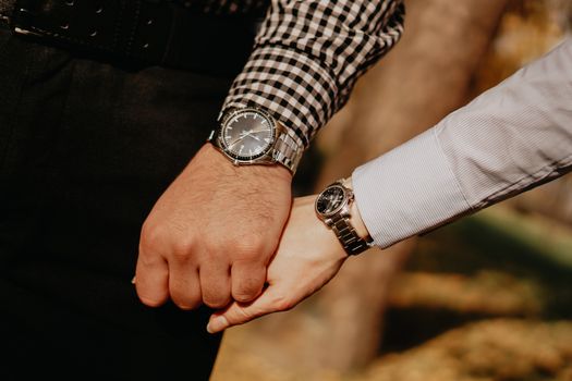 Hands of couple. Couple of lovers holding hands. Hand with wrist watch and ring