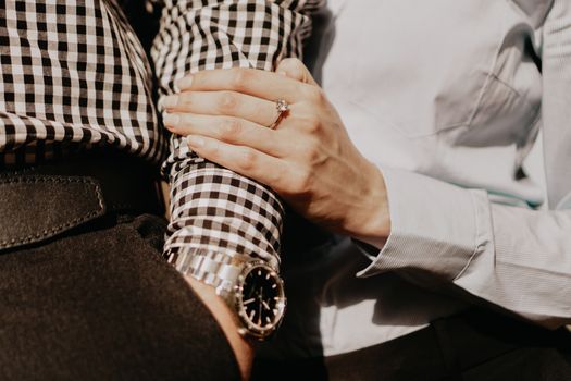 Hands of couple. Couple of lovers holding hands. Hand with wrist watch and ring