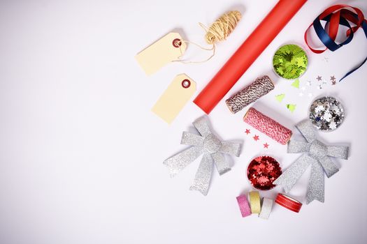 Gift wrapping items and Christmas decorations on white background. Christmas or winter composition. Flat lay, top view, copy space.