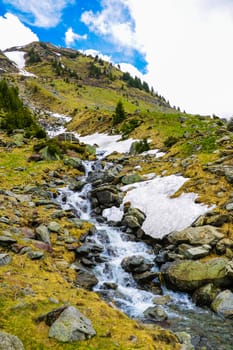 Mountain stream flows on a mountain slope, selective focus