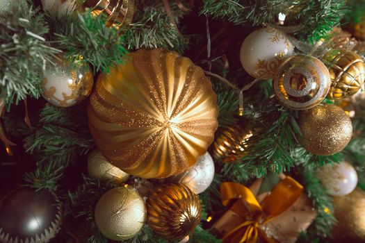 Toned stylish image of decorated christmas tree with golden baubles , abstract background