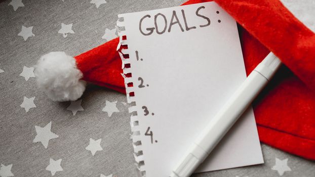 Notebook is with goals text on christmas background